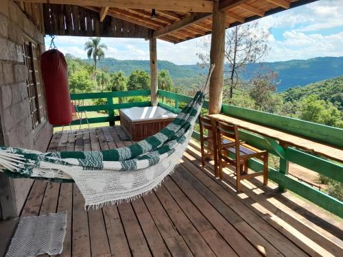 uma rede de descanso num deque com vista para as montanhas em Chácara paraíso dá paz em Nova Petrópolis