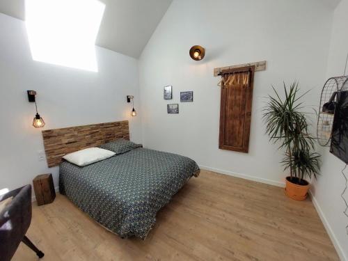 ein Schlafzimmer mit einem Bett und einer Pflanze darin in der Unterkunft Charming granite stone cottage between land and sea, in St Pol de Leon in Saint-Pol-de-Léon