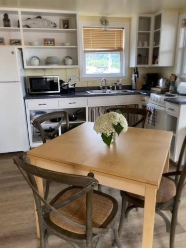 a kitchen with a wooden table with a vase of flowers on it at Floating Cottage on the River Nantucket in Savanna