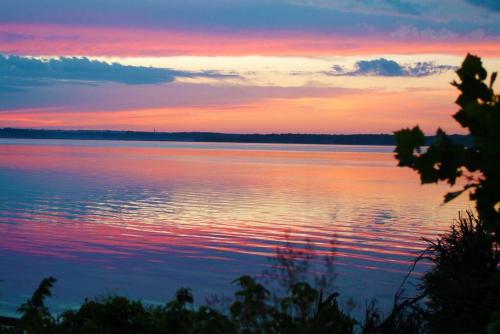 una puesta de sol sobre un gran cuerpo de agua en Floating Cottage on the River Nantucket, en Savanna