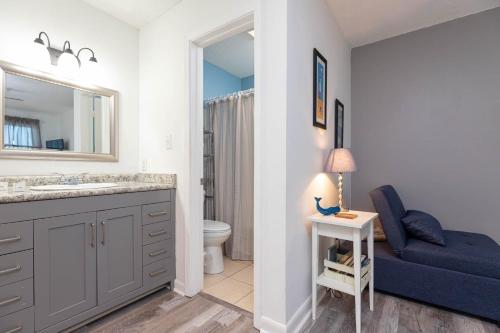 a bathroom with a sink and a toilet and a blue couch at Sugar Beach 304 condo in Gulf Shores