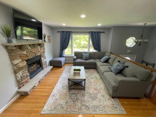 a living room with a couch and a fireplace at Spacious Pocono Home with Hot Tub and Fire Pit in Long Pond