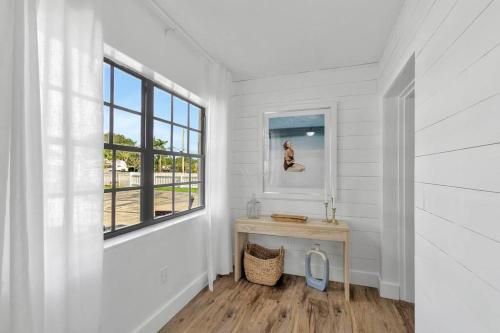 a white room with a table and a window at * NEW* The Bungalow Jupiter! - Moremoments Rentals in Jupiter