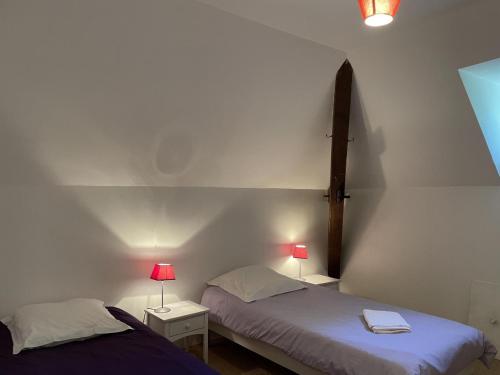 dwa łóżka w pokoju z krzyżem na ścianie w obiekcie Gîte Trévol, 5 pièces, 8 personnes - FR-1-489-223 w mieście Trévol