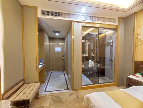 a bathroom with a shower and a bed in a room at Zhangye Kerry Hotel in Zhangye
