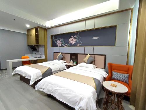 a hotel room with two beds and a table at Zhangye Kerry Hotel in Zhangye
