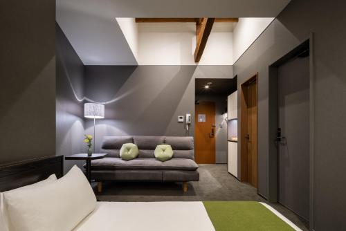a bedroom with a bed and a couch at THE MACHIYA HOTEL TAKAYAMA in Takayama