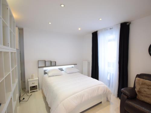 1 dormitorio blanco con 1 cama y 1 silla en Appartement Bernex, 2 pièces, 4 personnes - FR-1-498-87 en Bernex
