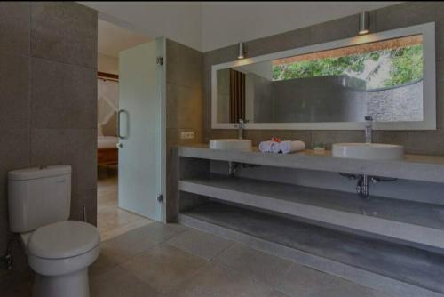 - Baño con 2 lavabos y aseo en Beachfront Private VILLA & POOL, en Banjar