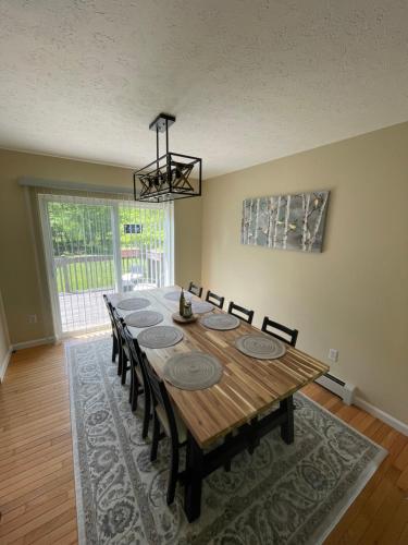 a dining room with a wooden table and chairs at Spacious Pocono Home with Hot Tub and Fire Pit in Long Pond