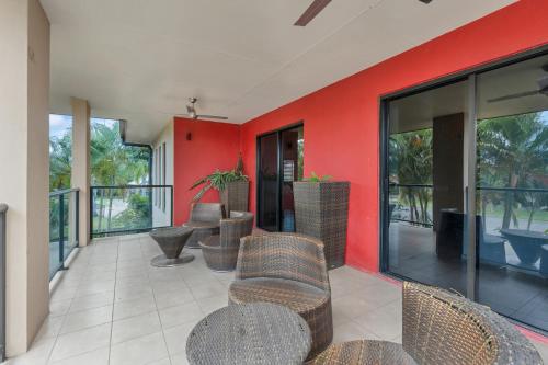 patio z krzesłami i czerwoną ścianą w obiekcie Western Gateway Motel and Apartments w mieście Emerald