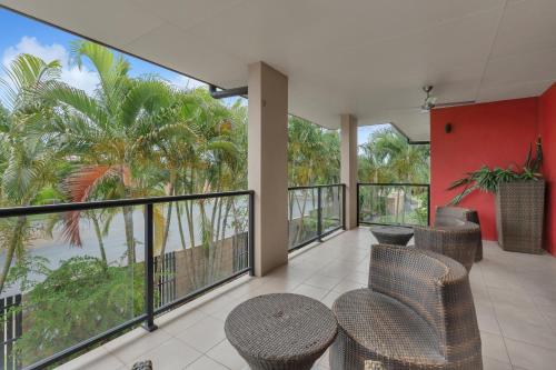 a balcony with wicker chairs and a table and some trees at Western Gateway Motel and Apartments in Emerald