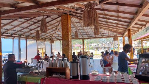 un grupo de personas en un pabellón con una mesa con comida en Howard Johnson by Wyndham Montañita, en Montañita