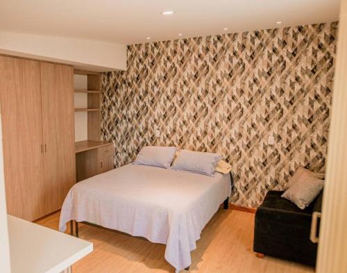 Dormitorio pequeño con cama y pared en Hermoso Apartamento amoblado, excelente ubicación, en Manizales