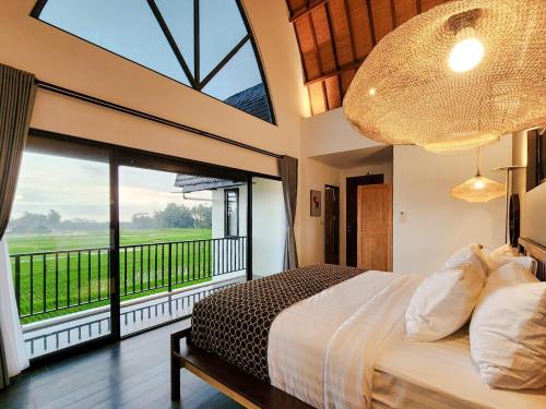 a bedroom with a large bed and a large window at Asri Cinta Villa Ubud in Ubud