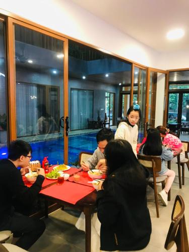 eine Gruppe von Menschen, die an einem Tisch in einem Restaurant sitzen in der Unterkunft Moon Sun Boutique Villa Hotel in Hue