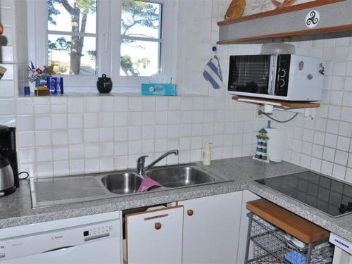 une cuisine avec un évier et un micro-ondes dans l'établissement Maison Bretonne à 50m de la Plage avec Jardin, WIFI et Vélos - Trégastel - FR-1-368-27, à Trégastel