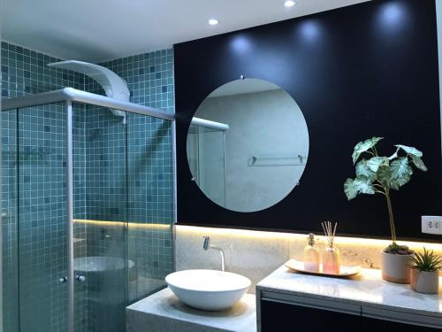 a bathroom with a sink and a mirror at FLAT ENCANTADOR A UM PASSO DA PRAIA in Salvador