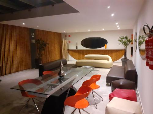 a living room with a glass table and leather chairs at FLAT ENCANTADOR A UM PASSO DA PRAIA in Salvador