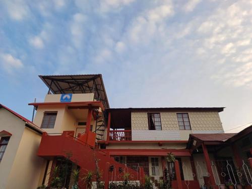 a building with a blue sign on the side of it at Odyssey's Pateng Homestay, Cherrapunji in Cherrapunji