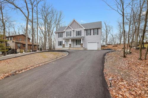 a house on a road with a driveway at Modern 5BR, Kid-Friendly Home In Poconos with Pool Table in East Stroudsburg