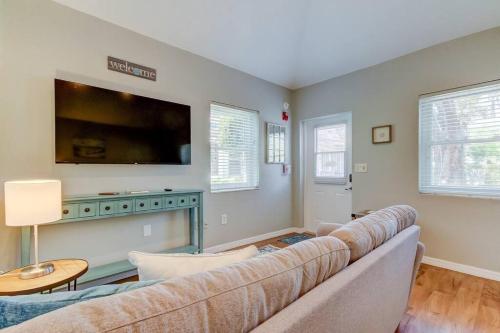 a living room with a couch and a flat screen tv at Beautiful Studio in Downtown Dunedin! in Dunedin