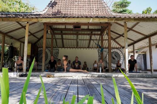a group of people doing yoga in a pavilion at S Resorts Hidden Valley Bali in Uluwatu