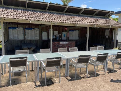 a long table and chairs in front of a building at Private Suite Nautilus Beach Front Resort in Coffs Harbour