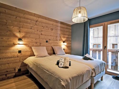 une chambre avec un grand lit avec un mur en bois dans l'établissement Appartement de standing, 8 pers, 3 chambres, balcon, cheminée, au cœur de Saint Martin de Belleville - FR-1-613B-11, à Saint-Martin-de-Belleville