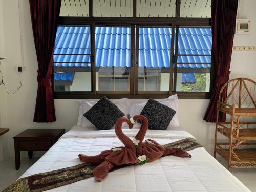 two swans sitting on a bed in a bedroom at Koh Jum Serenity Resort in Ko Jum