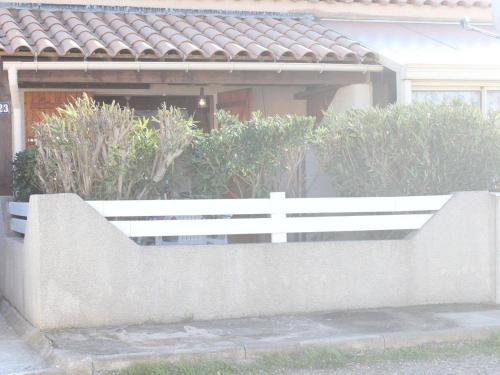 un banc blanc devant une maison dans l'établissement Maison studio avec mezzanine et terrasse - Gruissan - FR-1-229-841, à Gruissan