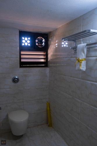 a bathroom with a toilet and a window at Reunion Ocean Royal (Beach House) in Pāngāla