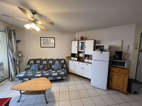 - un salon avec un lit et un réfrigérateur dans l'établissement Charmant T2 Cabine en Centre-Ville, 6 Pers., 200m de la Plage - Animaux -10kg OK - FR-1-701-47, à Valras-Plage