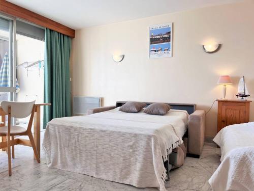 une chambre avec un lit, une chaise et une fenêtre dans l'établissement Appartement 2 pièces sur la plage - 5 couchages - FR-1-251-443, au Lavandou