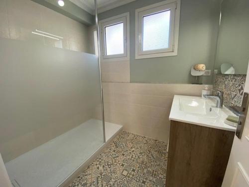 W łazience znajduje się prysznic, umywalka i wanna. w obiekcie Appartement rénové 85m2, terrasse, parking, face à plage - FR-1-494-149 w mieście Royan
