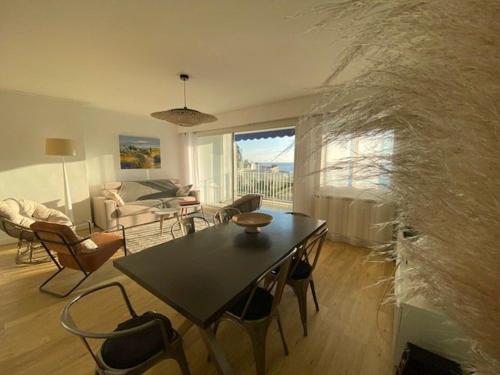 un salon avec une table et un canapé dans l'établissement Appartement rénové 85m2, terrasse, parking, face à plage - FR-1-494-149, à Royan
