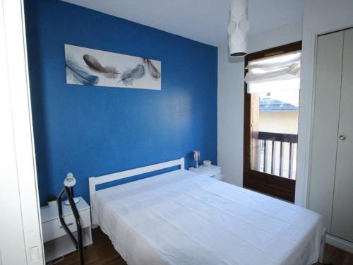 une chambre avec un mur bleu et un lit dans l'établissement Luchon T3 balcon sud, parking, petits animaux admis - FR-1-313-220, à Luchon