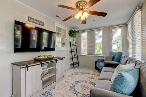 a living room with a couch and a flat screen tv at Light & Bright! Quaint Downtown Dunedin Bungalow! in Dunedin
