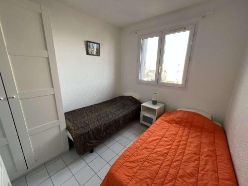 une petite chambre avec un lit et une fenêtre dans l'établissement Appartement 4 couchages avec clim, terrasse, piscine et accès direct à la mer - FR-1-387-192, à Marseillan