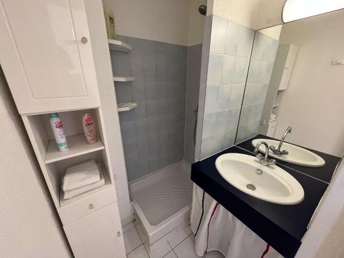une petite salle de bain avec un lavabo et une douche dans l'établissement Appartement 4 couchages avec clim, terrasse, piscine et accès direct à la mer - FR-1-387-192, à Marseillan
