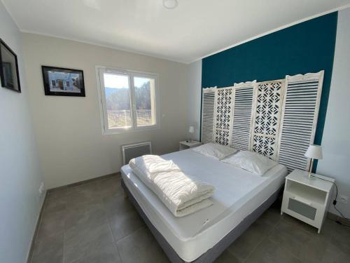 een slaapkamer met een wit bed en een blauwe muur bij Maison Vallon-Pont-d'Arc, 4 pièces, 6 personnes - FR-1-697-9 in Vallon-Pont-dʼArc