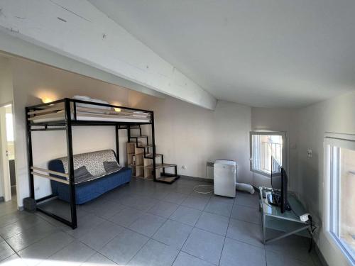 een slaapkamer met een stapelbed en een bureau met een televisie bij Studio Valras-Plage, 1 pièce, 4 personnes - FR-1-701-51 in Valras-Plage