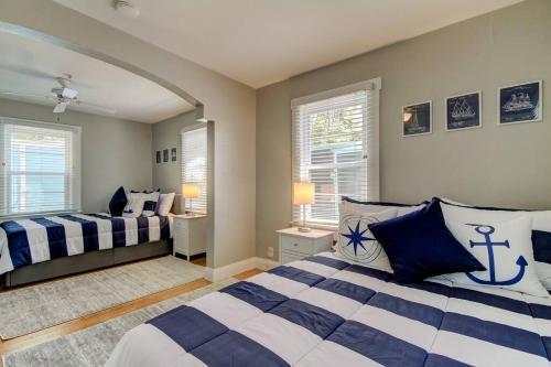 a bedroom with two beds and two windows at Rare- Downtown 2 bedroom! Family friendly! in Dunedin
