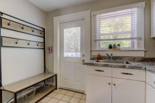 a kitchen with white cabinets and a sink and a window at Rare- Downtown 2 bedroom! Family friendly! in Dunedin