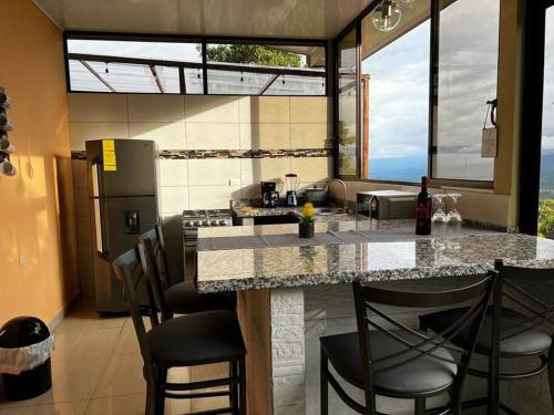 - une cuisine avec un comptoir avec des chaises et un comptoir dans l'établissement Villas Altos del Arenal, à Fortuna