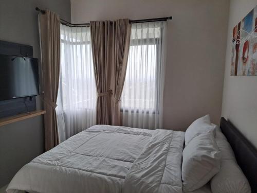 Una cama o camas en una habitación de Tabebuya Rumah Liburan Keluarga