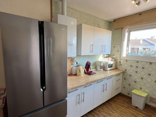 une cuisine avec un réfrigérateur en acier inoxydable et des armoires blanches dans l'établissement Maison avec Jardin, Centre-Ville, Proche Plage, 6 Pers. - FR-1-701-50, à Valras-Plage