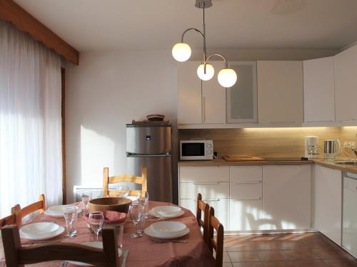 une cuisine avec une table en bois et des chaises ainsi qu'une salle à manger dans l'établissement Appartement cosy 2 pièces avec coin nuit, 6 couchages, à 100m des pistes et commerces à Vars - FR-1-330B-207, à Vars