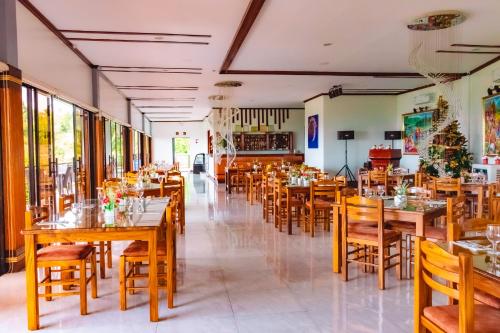 a restaurant with wooden tables and chairs at Marqis Sunrise Sunset Resort and Spa in Baclayon