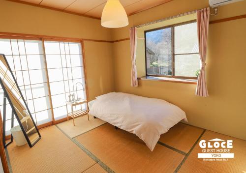 a room with a bed and two windows at GLOCE 養老 西小倉ハウス 1 l 広々とした一軒家を貸切 l 無料駐車場有 l 中長期向け in Yoro